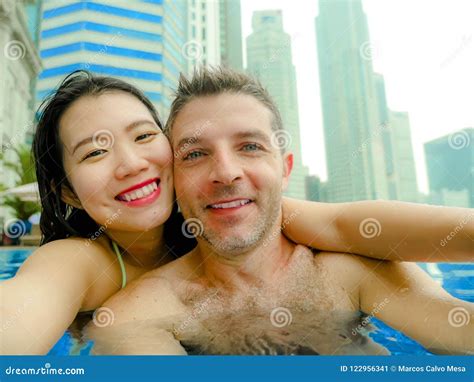 Young Happy And Attractive Playful Couple Taking Selfie Picture Together With Mobile Phone At
