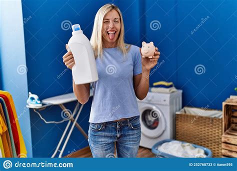 Beautiful Woman Doing Laundry Holding Detergent Bottle And Piggy Bank