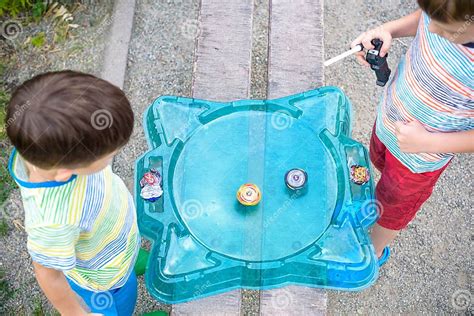 Two Boys Playing With A Spinning Top Kid Toy Popular Children Game