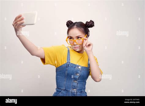 Young Pretty Asian Girl Who Wearing A Jeans Dungaree And Yellow Glasses Taking Selfie Smiling