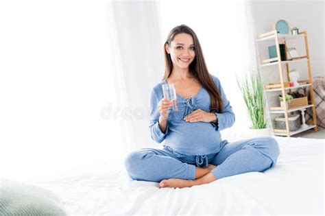 Photo Of Sweet Tender Adorable Cheerful Pregnant Mom In Nightwear Drinking Fresh Water Vitamins