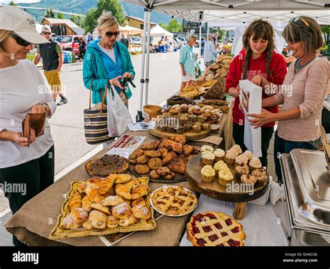 Customers And Vendors Buying Bakery Goods At Weekly Summer Farmers Market