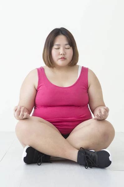 Young Fat Asian Woman Sitting On The Floor Hands On Her Knees With Her
