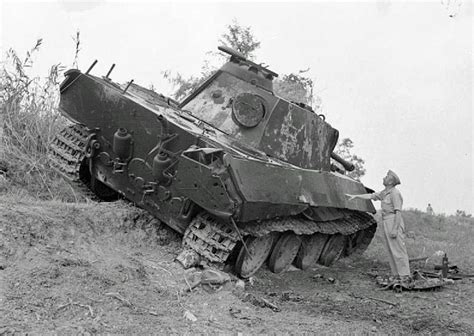The Remains Of A Destroyed German Panther Tank Sit On The Roadside Near