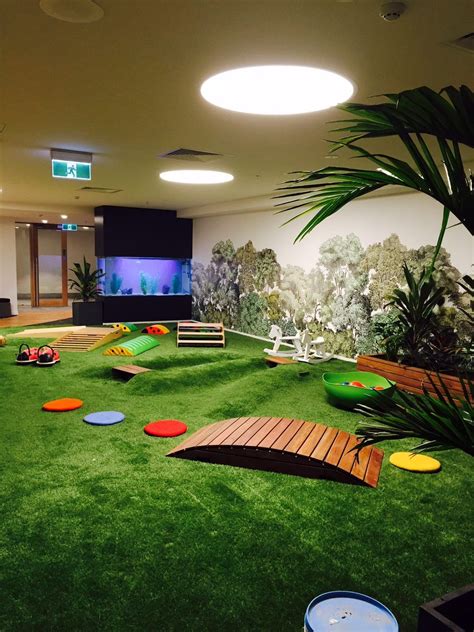 An Indoor Play Area With Artificial Grass And Toys