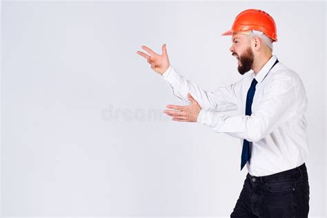 Angry Man In A Protective Helmet Of A Builder On An Isolated White