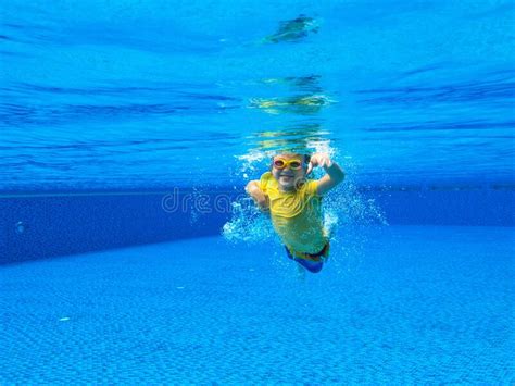 A Child Underwater Swims In A Pool With Clear Blue Water Stock Photo