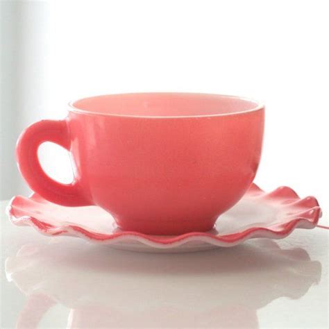 A Pink Cup And Saucer On A White Table