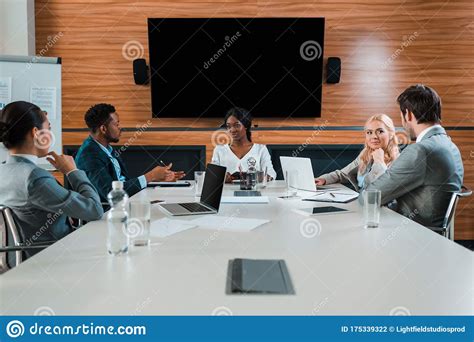 Young Multicultural Businesspeople Talking During Meeting Stock Photo