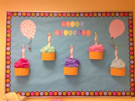 Birthday Cupcakes With Candles On Them In Front Of A Bulletin Board