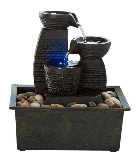 A Water Fountain With Rocks In It On Top Of A Table