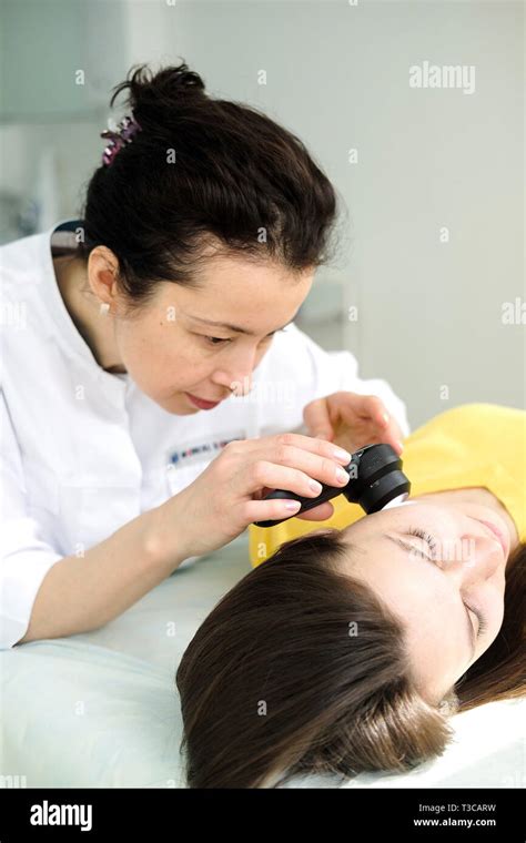 Female Dermatologist Using A Professional Dermatoscope While Doing Skin