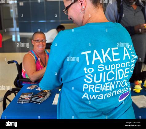 An Event Staff Member Wearing A Suicide Prevention Shirt Explains The