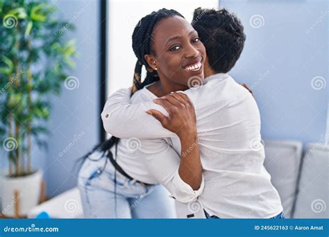 African American Mother And Son Hugging Each Other Standing At Home