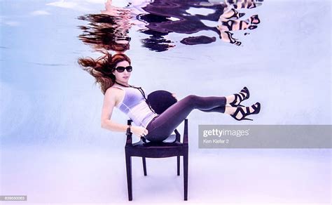 Underwater Side View Of Mid Adult Woman Wearing High Heels And