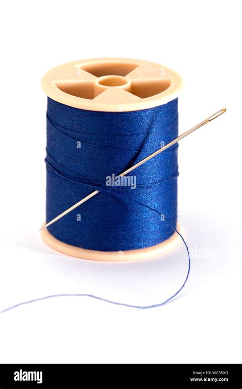 Single Spool Of Blue Thread And Sewing Needle On White Background Stock