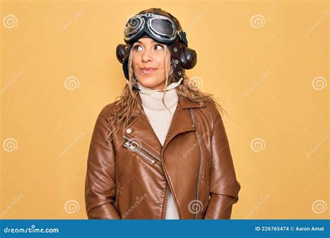 Young Beautiful Blonde Aviator Woman Wearing Vintage Pilot Helmet Whit Glasses And Jacket