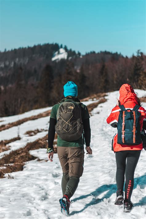 Two People Walking On Snow Trail · Free Stock Photo