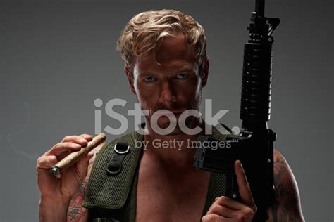 Macho Man Holding An M16 Assault Rifle And A Cigar Stock Photo