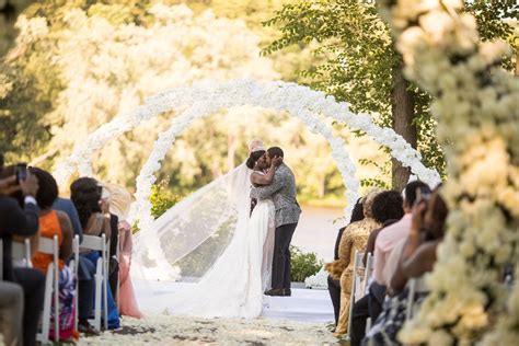Bride And Groom Kiss Under Floral Arches