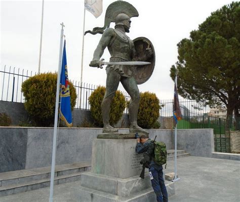 A Greek Soldier Resting Upon The Statue Of King Leonidas During The