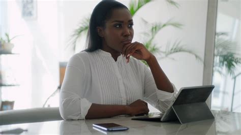 Thoughtful Black Woman Writing Email For Work On Laptop At Home Office
