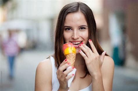 Young Woman Eating Ice Cream On The Street Stocksy United