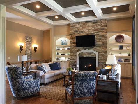 Lighted Shelves Flank A Stone Fireplace Beneath A Dramatic Coffered