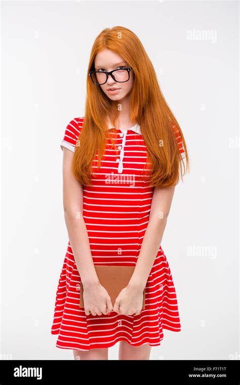 Cute Shy Young Woman In Glasses With Long Red Hair Standing And Holding
