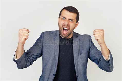 Young Businessman Man With A Beard Angry And Insane Raising His Fists