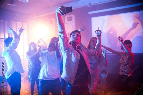 Crowd Of Trendy Young People Dancing In Nightclub And Enjoying Party Focus On Handsome Young