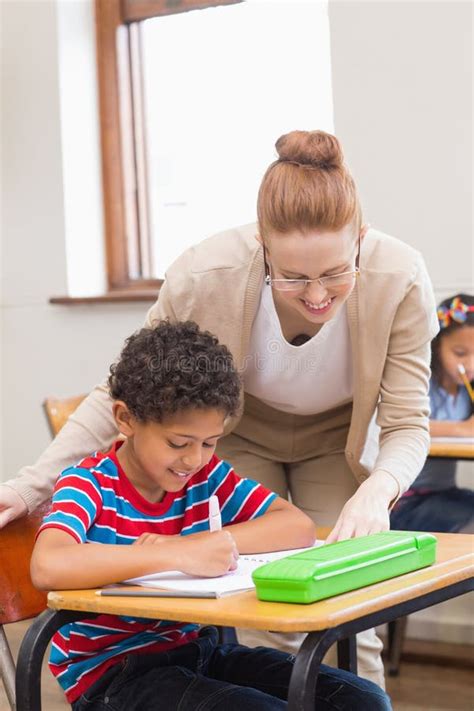 Pretty Teacher Helping Pupil In Classroom Stock Image Image Of Happy