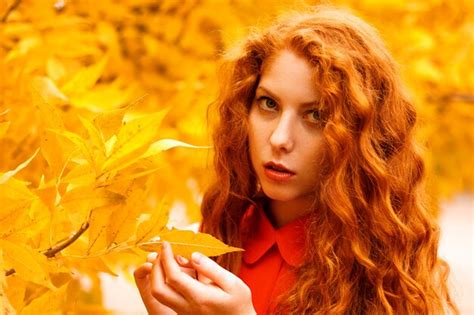 Premium Photo Portrait Of A Beautiful Red Haired Girl In A Red Dress Against Yellow Leaves