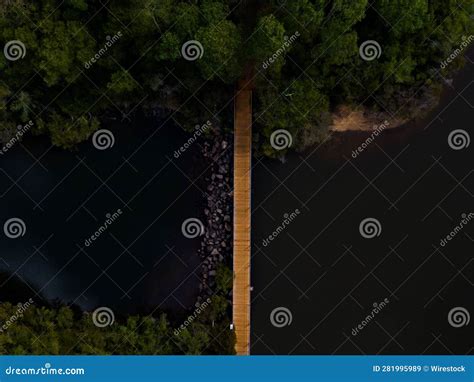 Aerial Top View Of A Wooden Bridge Over A River In A Green Forest Stock