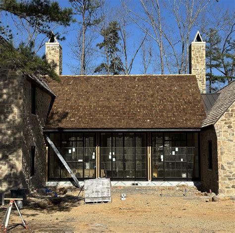 An Old Brick House With Windows And Shingles On The Roof Is Being Built