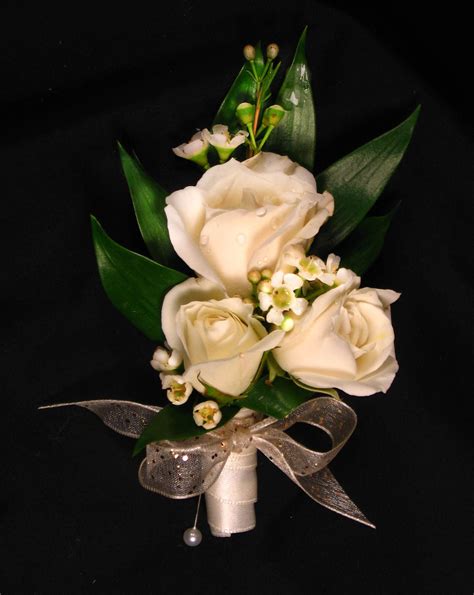 A Bridal Bouquet With White Roses And Greenery On A Black Background