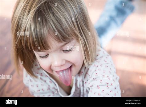 Portrait Of Little Girl With Outstretched Tongue Stock