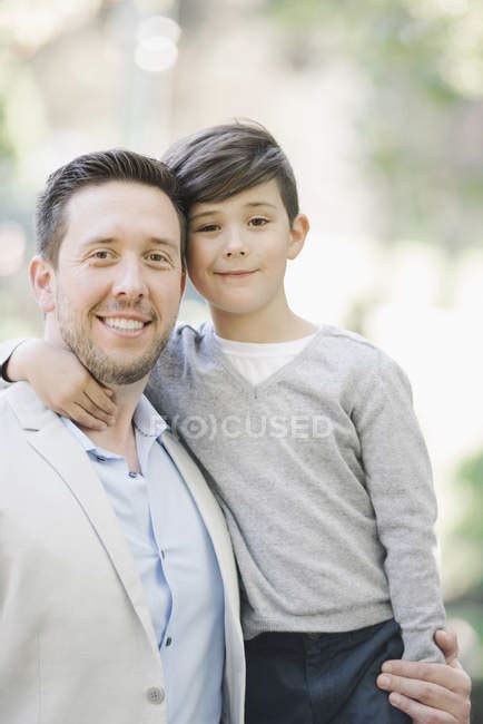 Portrait Of Smiling Father And Son Embracing Outdoors — Pre Teen Boy