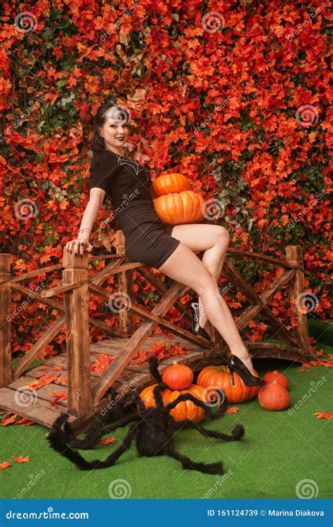 And Attractive Brunette Witch In Autumn Colorful Park With Orange And