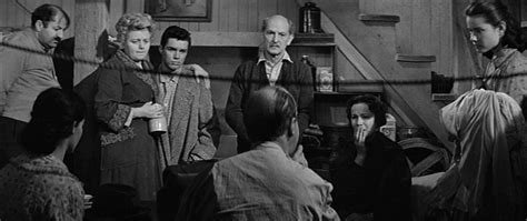 Anne is seated at the center table, writing in herdiary. Movie Review - Diary Of Anne Frank, The - Fernby Films