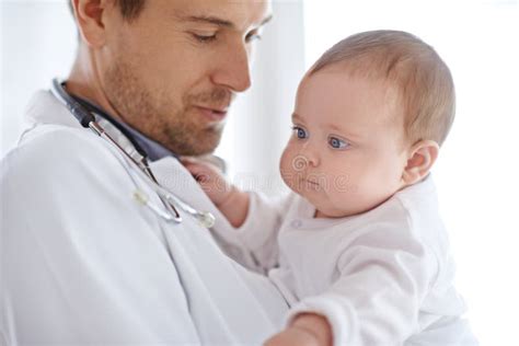 Doctor Pediatrician And Holding Baby For Healthcare Assessment