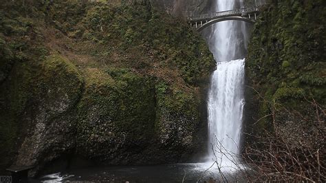 A Large Waterfall With A Bridge Over It