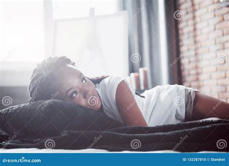 A Beautiful African Woman Lies And Sleeps In Bed In A White Bedroom