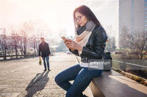 Young Woman Waiting For Her Boyfriend And Texting On The Phone High Res