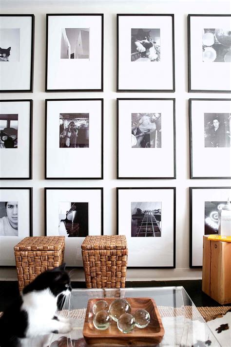 Black And White Framed Photographs Fill A Wall From The Ceiling To The