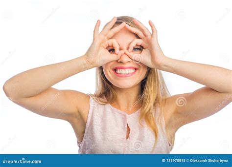 The Girl Looks Through Her Fingers In Form Of Glasses On An Isolated