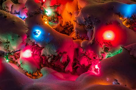 Christmas Lights Under A Blanket Of Snow At Night Stock Photo