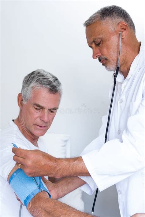 Doctor Checking Senior Mans Blood Pressure Stock Photo Image Of