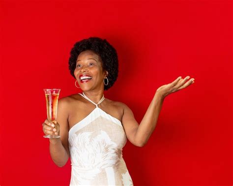 premium photo black woman smiling and holding a glass with champagne in hands