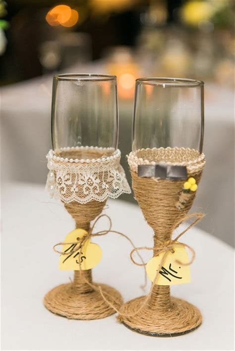 Two Wine Goblets With Lace And Twine Wrapped Around Them On A Table